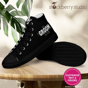Pu&ograve; includere: Scarpe da ginnastica alte nere con lacci bianchi e la parola "Groom" in lettere bianche con accenti dorati. Le scarpe sono su una superficie di legno con un cerchio rosa che dice "Personalizza testo e colori".