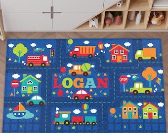 May include: A blue and green children's play rug with a city street theme. The rug features a variety of vehicles, houses, and a stop sign. The name "LOGAN" is spelled out in large letters in the center of the rug.