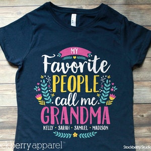 May include: Navy blue t-shirt with a pink and yellow graphic that says "My Favorite People Call Me Grandma" with the names Kelly, Sarah, Samuel, and Madison underneath.