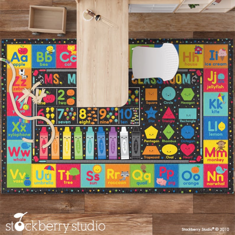 May include: A black and white alphabet and number learning rug with colorful illustrations of animals, objects, and shapes. The rug features the letters A through Z, the numbers 1 through 10, and various shapes such as a square, circle, hexagon, triangle, rectangle, pentagon, rhombus, octagon, trapezoid, oval, and heart. The rug also includes the words "classroom" and "MS. M".