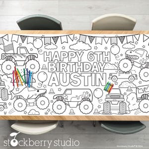 May include: A black and white coloring table cover featuring monster trucks, a shark, and the text "Happy 6th Birthday Austin".