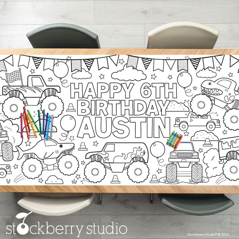 May include: A black and white coloring table cover featuring monster trucks, a shark, and the text "Happy 6th Birthday Austin".
