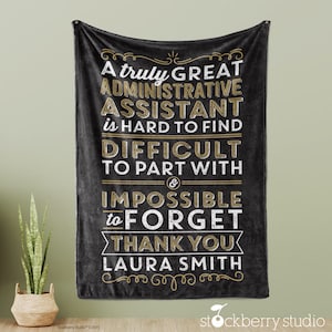 Puede incluir: Una manta de franela negra con un diseño dorado y blanco que dice "A truly GREAT ADMINISTRATIVE ASSISTANT is HARD TO FIND DIFFICULT TO PART WITH & IMPOSSIBLE to FORGET THANK YOU LAURA SMITH".