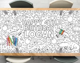 May include: A white and black coloring table runner with the text "HAPPY 4TH BIRTHDAY LOGAN" and illustrations of reptiles, balloons, and leaves. Colored pencils are on the left side of the runner.