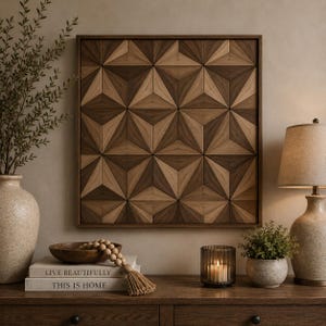 Op de afbeelding: Een vierkant houten wandkunstwerk met een geometrisch patroon van in elkaar grijpende driehoeken in verschillende tinten licht en donkerbruin hout, omlijst door een dunne donkere houten rand, wat een driedimensionaal visueel effect creëert.
