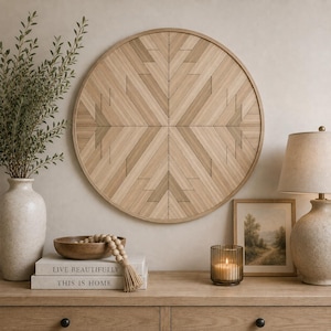 May include: A circular wooden wall art piece featuring a geometric pattern of light and medium brown wood slats arranged in a symmetrical chevron design, framed by a thin circular border that complements the natural wood grain texture.
