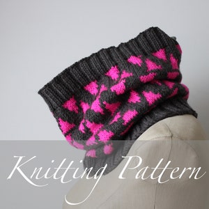 Könnte beinhalten: Strickanleitung für einen grauen und pinkfarbenen Loop mit geometrischem Muster. Der Loop ist auf einer Schaufensterpuppe gezeigt.