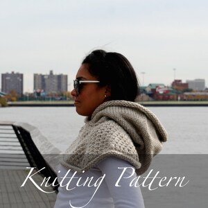 May include: A woman wearing a grey hooded knitted cape with a city skyline in the background. The text "Knitting Pattern" is displayed at the bottom of the image.