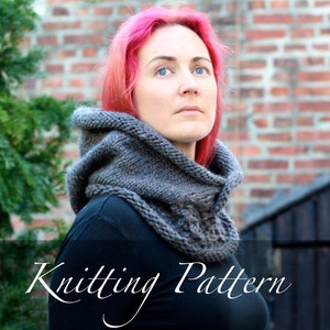 Könnte beinhalten: Ein grauer Strickkragen mit Kapuze, getragen von einer Person mit pinkfarbenem Haar. Der Kragen hat ein strukturiertes Muster und wird mit einem schwarzen Shirt kombiniert. Der Text "Knitting Pattern" ist am unteren Rand des Bildes sichtbar.