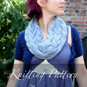 May include: A woman wearing a blue knitted cowl neck scarf with a blue and black cardigan and a blue dress. The text "Knitting Pattern" is visible at the bottom of the image.