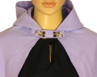 May include: A lavender hooded cape with a decorative floral brooch. The cape is made of a soft, plush fabric.