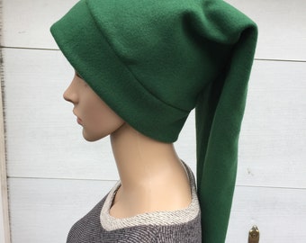 May include: A green fleece hat with a long pointed tail. The hat is being worn by a mannequin.