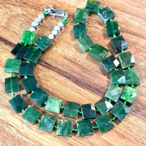 May include: A double-strand necklace made of green jade square beads with a silver clasp.