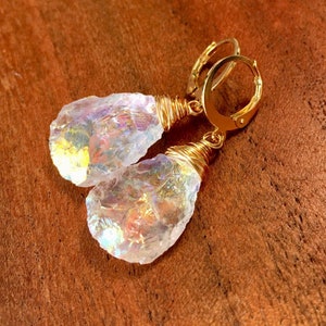 May include: Gold wire wrapped iridescent crystal earrings. The crystals are clear with rainbow flashes of color.