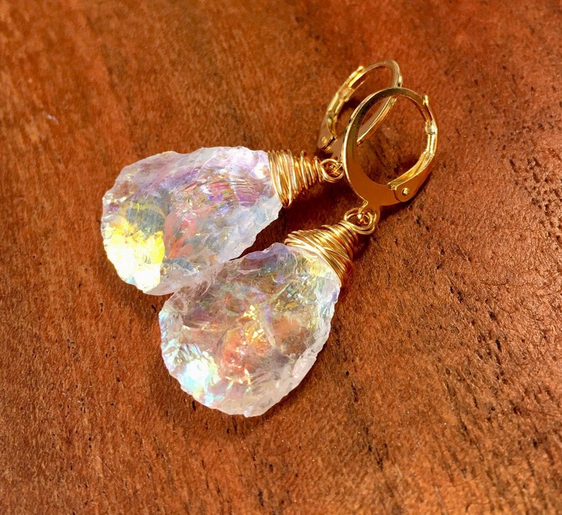 May include: Gold wire wrapped iridescent crystal earrings. The crystals are clear with rainbow flashes of color.