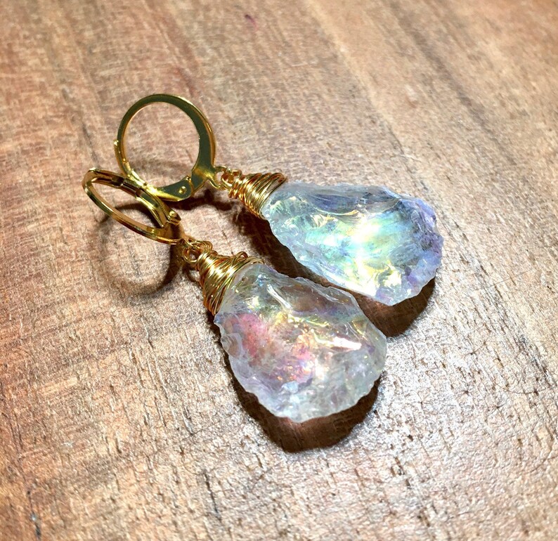 May include: Gold wire wrapped iridescent crystal earrings. The crystals are teardrop shaped and have a rainbow sheen.