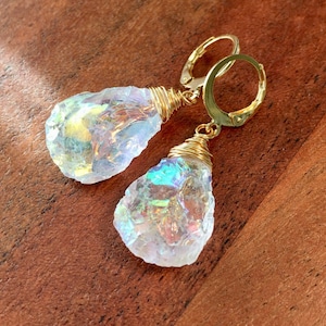 May include: A pair of iridescent crystal earrings with gold wire wrapped around the crystals and gold hoop ear wires.