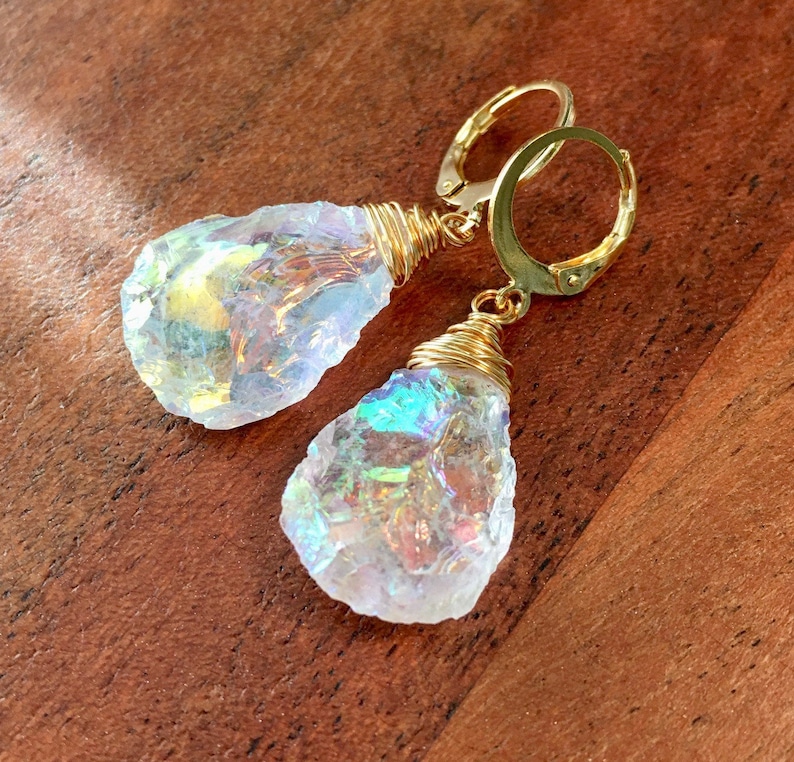 May include: A pair of iridescent crystal earrings with gold wire wrapped around the crystals and gold hoop ear wires.