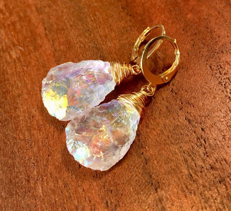 May include: Gold wire wrapped iridescent crystal earrings. The crystals are clear with rainbow flashes of color.
