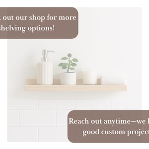 May include: A light wood floating shelf displays a white soap dispenser, a small potted plant, a candle, and a rolled white towel. The text reads, "Check out our shop for more shelving options!" and "Reach out anytime&mdash;we love a good custom project."