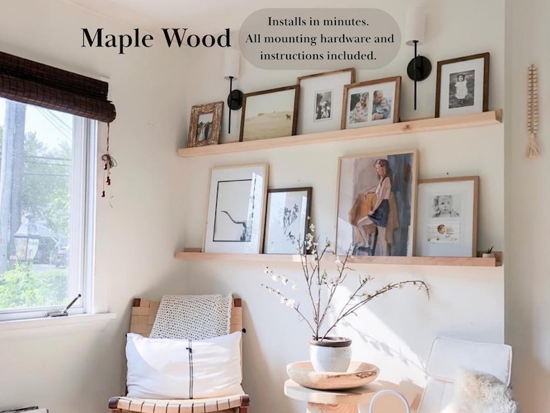 May include: Two wooden shelves with a variety of framed artwork, including a painting of a woman in a yellow dress, and a black and white drawing of a tree. The shelves are mounted on a white wall. The text "Maple Wood" and "Installs in minutes. All mounting hardware and instructions included." is visible in the image.