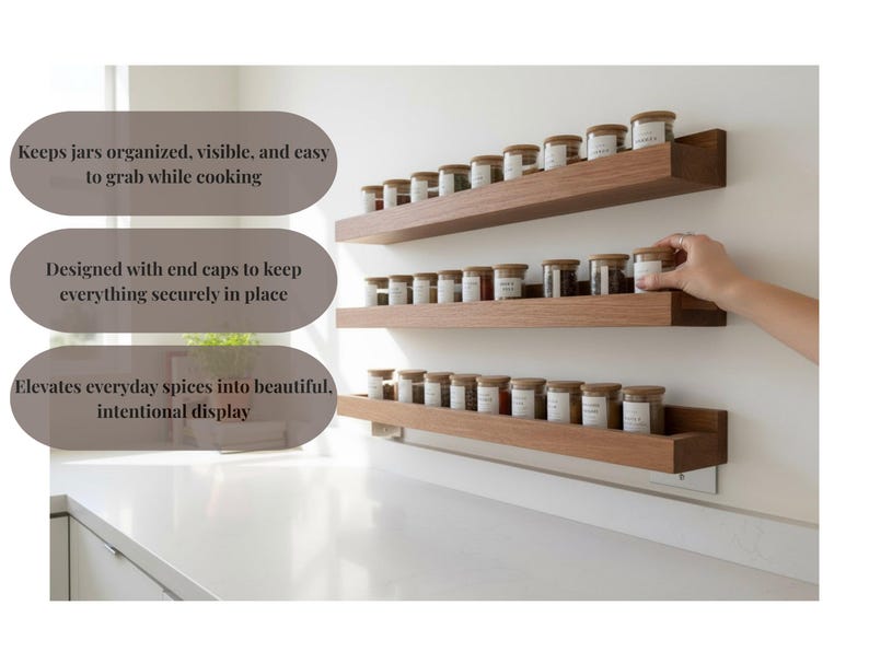 May include: Wooden spice rack with three shelves, each holding several small glass jars with labels and wooden lids. The rack is mounted on a white wall above a countertop. The text on the image says: Keeps jars organized, visible, and easy to grab while cooking.