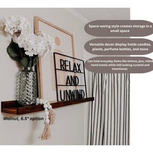 May include: A dark walnut floating shelf, 6.5 inches wide, displays a decorative vase with white flowers, a framed print, and a black metal sign that reads "RELAX AND UNWIND." The shelf is designed for small spaces and can hold candles, plants, and everyday items.