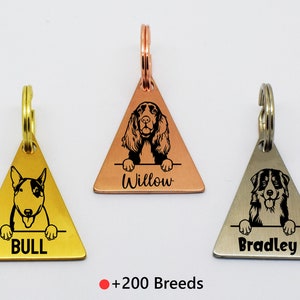 May include: Three triangular dog tags in gold, copper, and silver. Each tag features a different dog breed illustration and a name: "BULL", "Willow", and "Bradley". The text "+200 Breeds" is at the bottom.