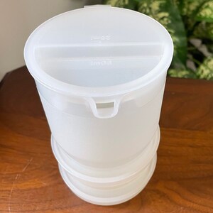 Peut inclure: Une carafe en plastique transparent avec un couvercle. Le couvercle a un bec verseur et les mots "1.00L" et "2.5L" imprimés dessus.