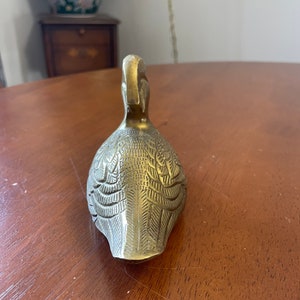 Puede incluir: Una figurita de pato de lat&oacute;n detallada con un dise&ntilde;o intrincado en su cuerpo. El pato est&aacute; mirando hacia adelante con la cabeza inclinada hacia atr&aacute;s.