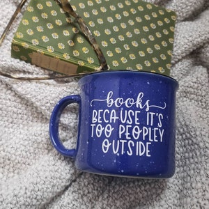 Puede incluir: Taza de cer&aacute;mica azul moteada con asa blanca y el texto "books because it's too peopley outside" en letras blancas en cursiva.