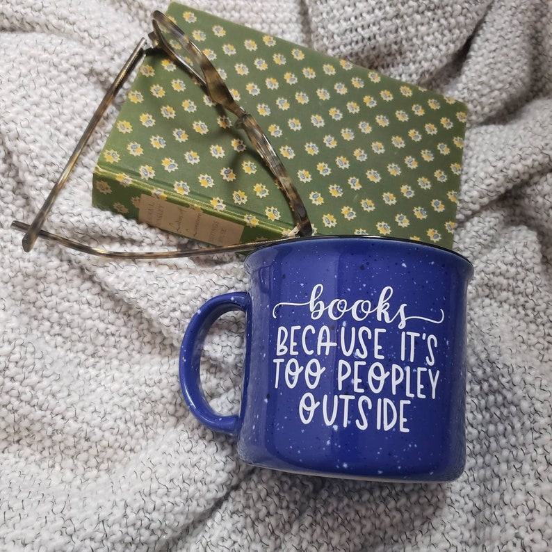 Puede incluir: Taza de cer&aacute;mica azul moteada con asa blanca y el texto "books because it's too peopley outside" en letras blancas en cursiva.