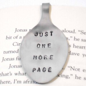 May include: A silver spoon bookmark with the text "JUST ONE MORE PAGE" stamped on it.