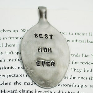 May include: A silver spoon pendant with the words "BEST MOM EVER" stamped on it. The spoon is a popular choice for personalized gifts.