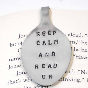 May include: A silver spoon bookmark with the text "Keep Calm and Read On" engraved on it.
