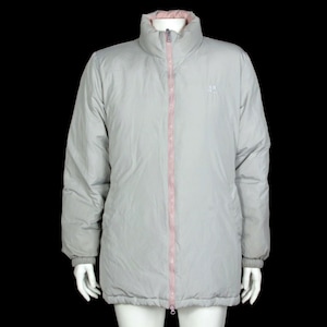 May include: A gray puffer jacket with a pink zipper and a small logo on the left chest. The jacket has a high collar and a long, slightly oversized fit.