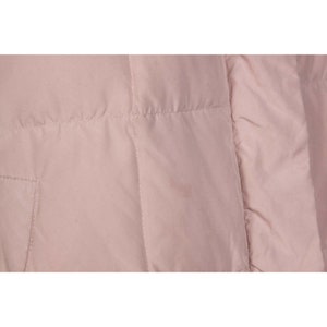 May include: A close-up of a pale pink quilted jacket. The jacket has a smooth, shiny finish and a subtle sheen.