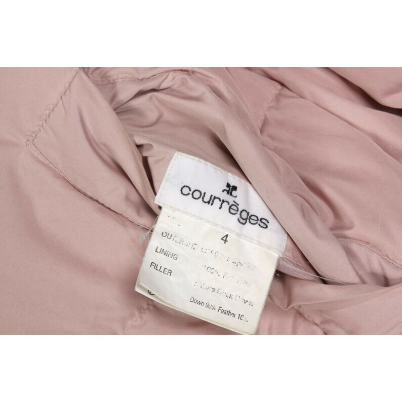May include: A white tag with black text that reads "Courr&egrave;ges" and "4". The tag is attached to a pink jacket. The tag also includes the following information: "Outer shell 100% Polyester", "Lining 100% Polyester", "Filler 90% Down 10% Feather".
