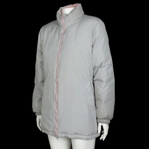 May include: A gray puffer jacket with a pink zipper and a pink lining. The jacket has a stand-up collar and long sleeves.