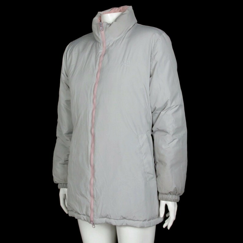 May include: A gray puffer jacket with a pink zipper and a pink lining. The jacket has a stand-up collar and long sleeves.