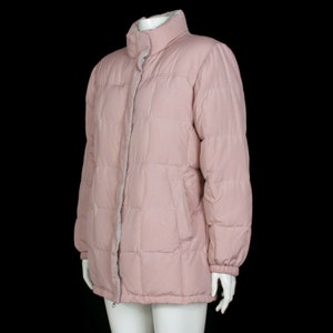 May include: A pink quilted puffer jacket with a zipper closure and a stand-up collar.