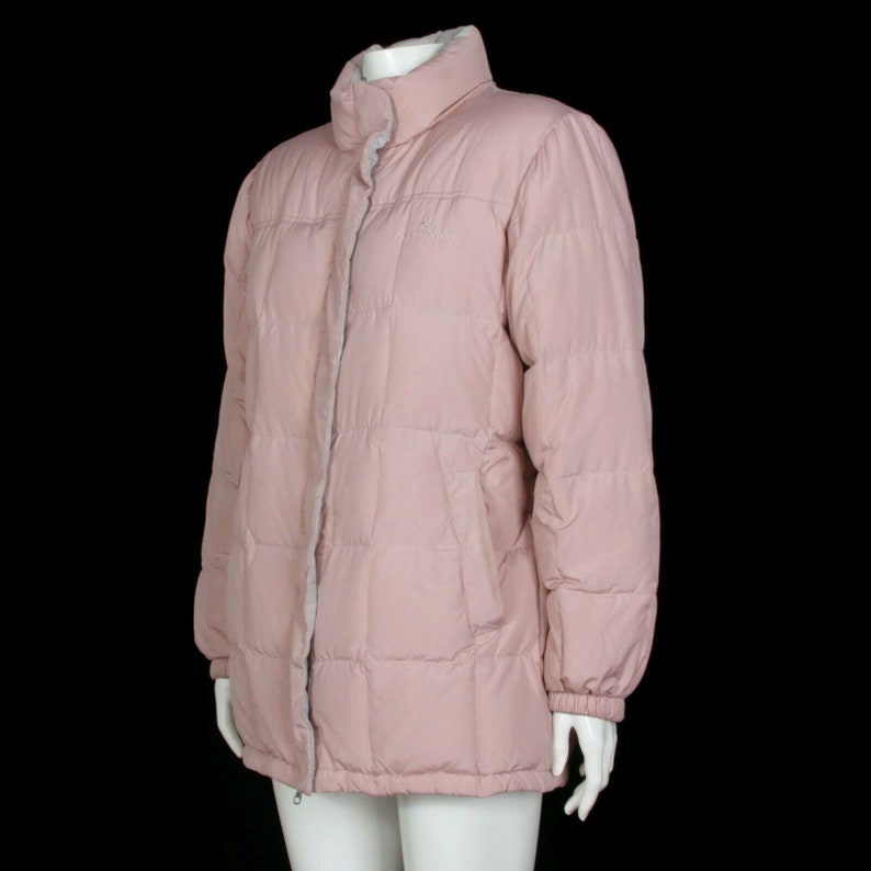 May include: A pink quilted puffer jacket with a zipper closure and a stand-up collar.