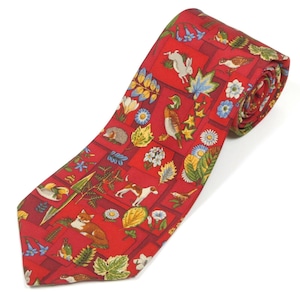 May include: A red necktie with a repeating pattern of woodland creatures and foliage. The tie features a fox, rabbit, duck, and dog, along with leaves and flowers. The tie is made of a smooth fabric and is suitable for formal or casual wear.