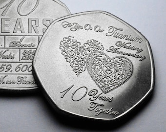 May include: Two silver coins commemorating a 10th wedding anniversary. The first coin reads "10 Years" and includes the number of weeks and days in 10 years. The second coin reads "For You On Our Titanium Wedding Anniversary" and features a decorative heart design.