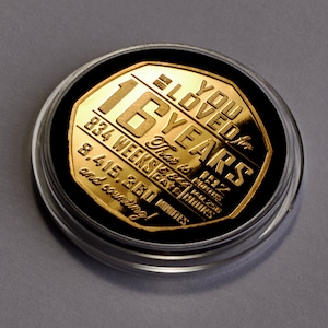 Puede incluir: Moneda de color dorado con el texto "I Loved You for 16 Years" y la fecha "1972". La moneda también incluye el número de semanas, días, horas y minutos en 16 años.