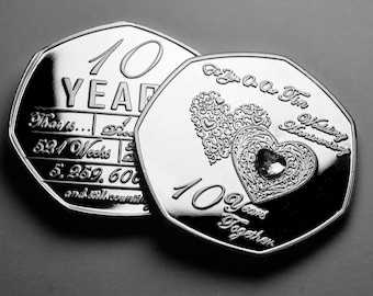 Puede incluir: Dos monedas de plata conmemorando un décimo aniversario de boda. La primera moneda presenta el texto "10 YEAR" y "That is... 521 Weeks | 5,259,600 and still counting". La segunda moneda presenta dos corazones entrelazados con un strass en el centro y el texto "For You On Our Ten Wedding Anniversary 10 Years Together".
