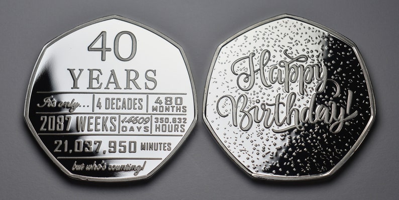 以下が含まれることがあります： 2つの銀貨。1つは「40 YEARS」と時間の計算、もう1つは筆記体で「Happy Birthday!」と書かれています。最初のコインには「It's only... 4 decades, 480 months, 2087 weeks, 14609 days, 350,632 hours, 21,037,950 minutes」と書かれています。