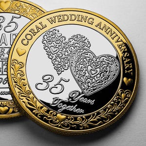 Könnte beinhalten: Eine Gold-Silber-Münze zum 35. Hochzeitstag. Die Münze zeigt zwei verzierte Herzen, die Worte "Coral Wedding Anniversary" und die Inschrift "35 Years Together".