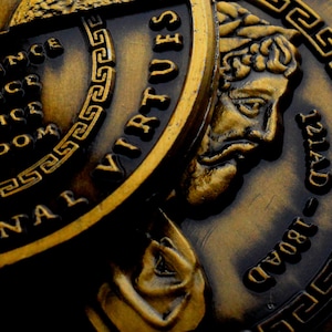 May include: Close-up of three gold-toned coins with raised lettering and a Greek key design. The coins feature the words "Seven Virtues" and "Grand 1804 121AD".