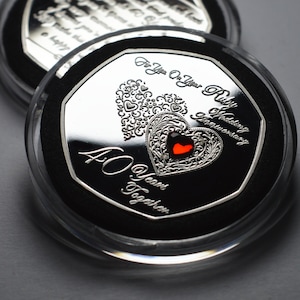 Op de afbeelding: Een zilveren munt met een rood hart en de inscriptie "For You On Your Ruby Wedding Anniversary 40 Years Together" in een transparante kunststof display.